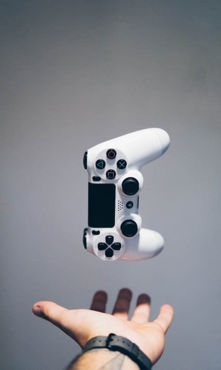 white Sony PS4 DualShock controller over shopper's palm