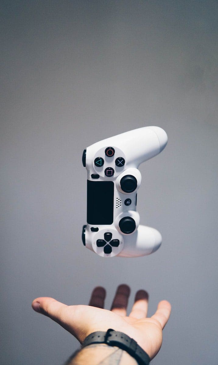 white Sony PS4 DualShock controller over shopper's palm