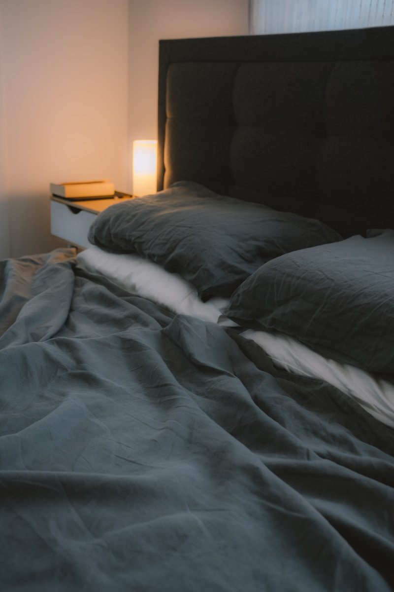 black bed threads linen near brown wooden nightstand