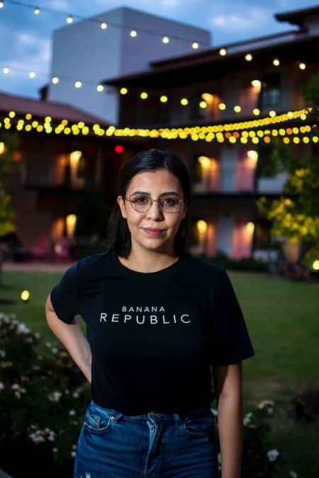 smiling woman in black banana republic t-shirt and black framed eyeglasses